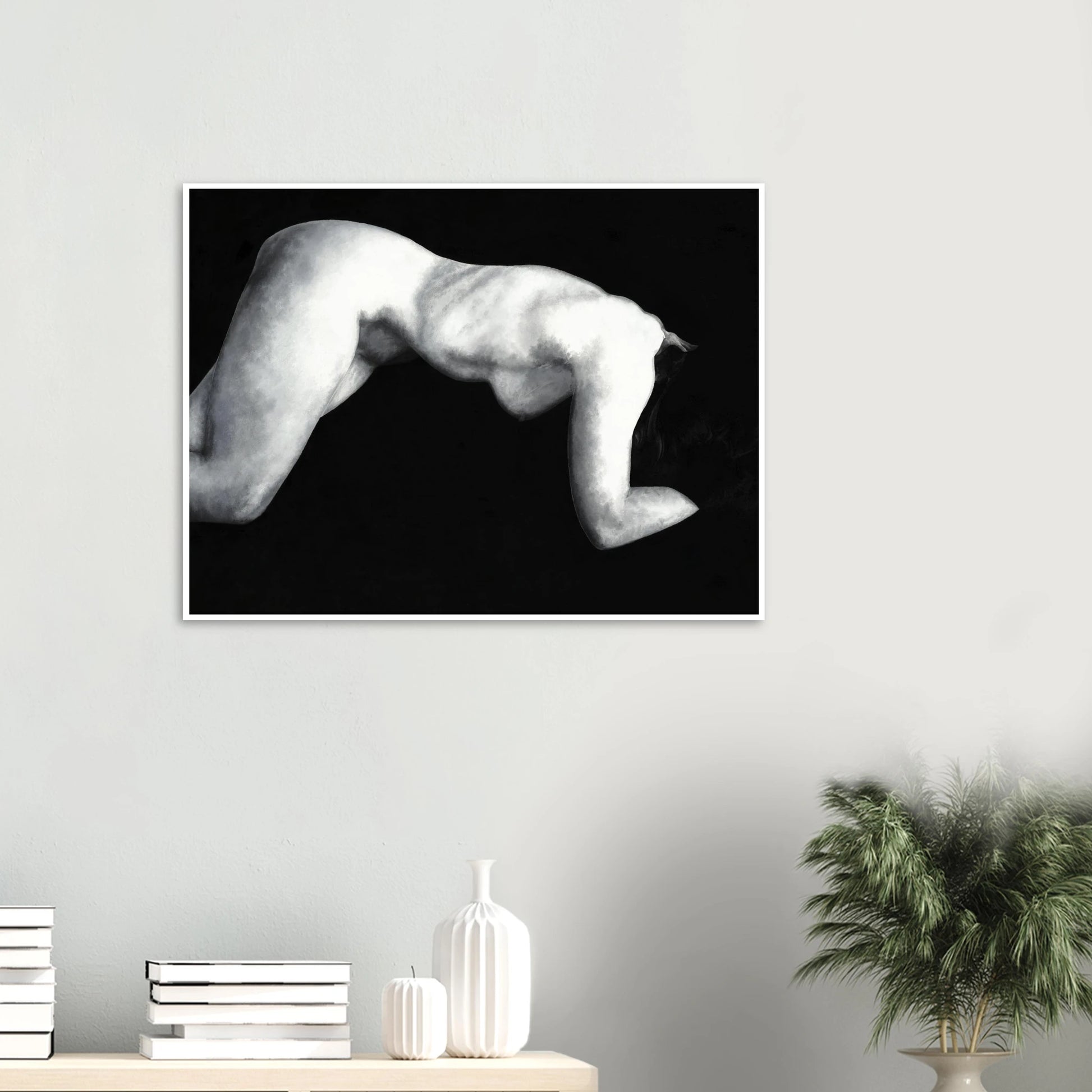 A black and white artwork print of a reclining nude figure on a wall above a shelf with decorative items.