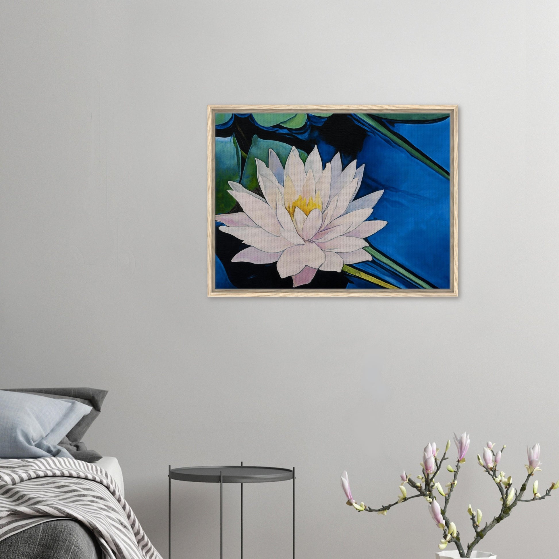 Framed artwork of a water lily on a wall above a bed.