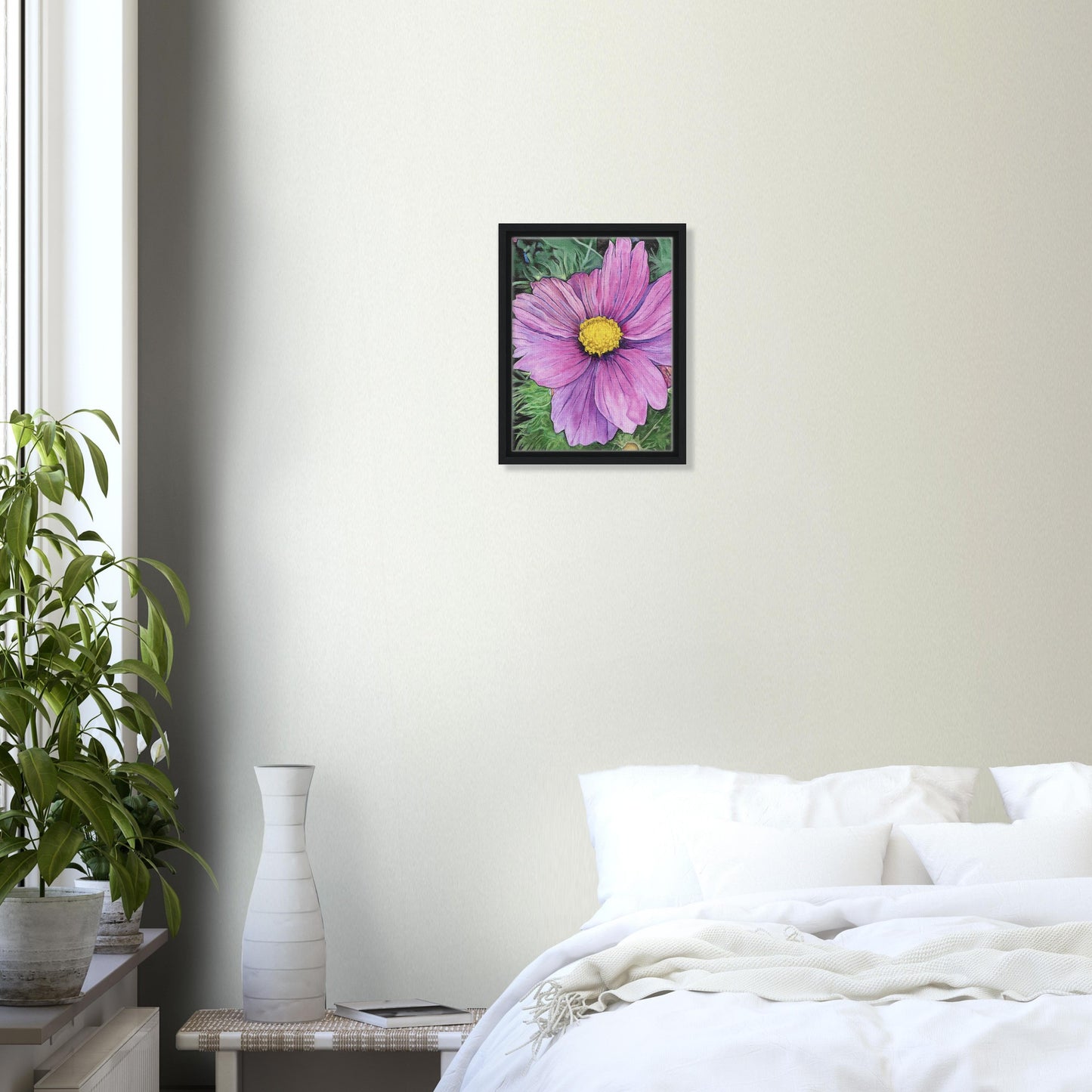 Framed pink flower painting on a wall above a bed in a bedroom.