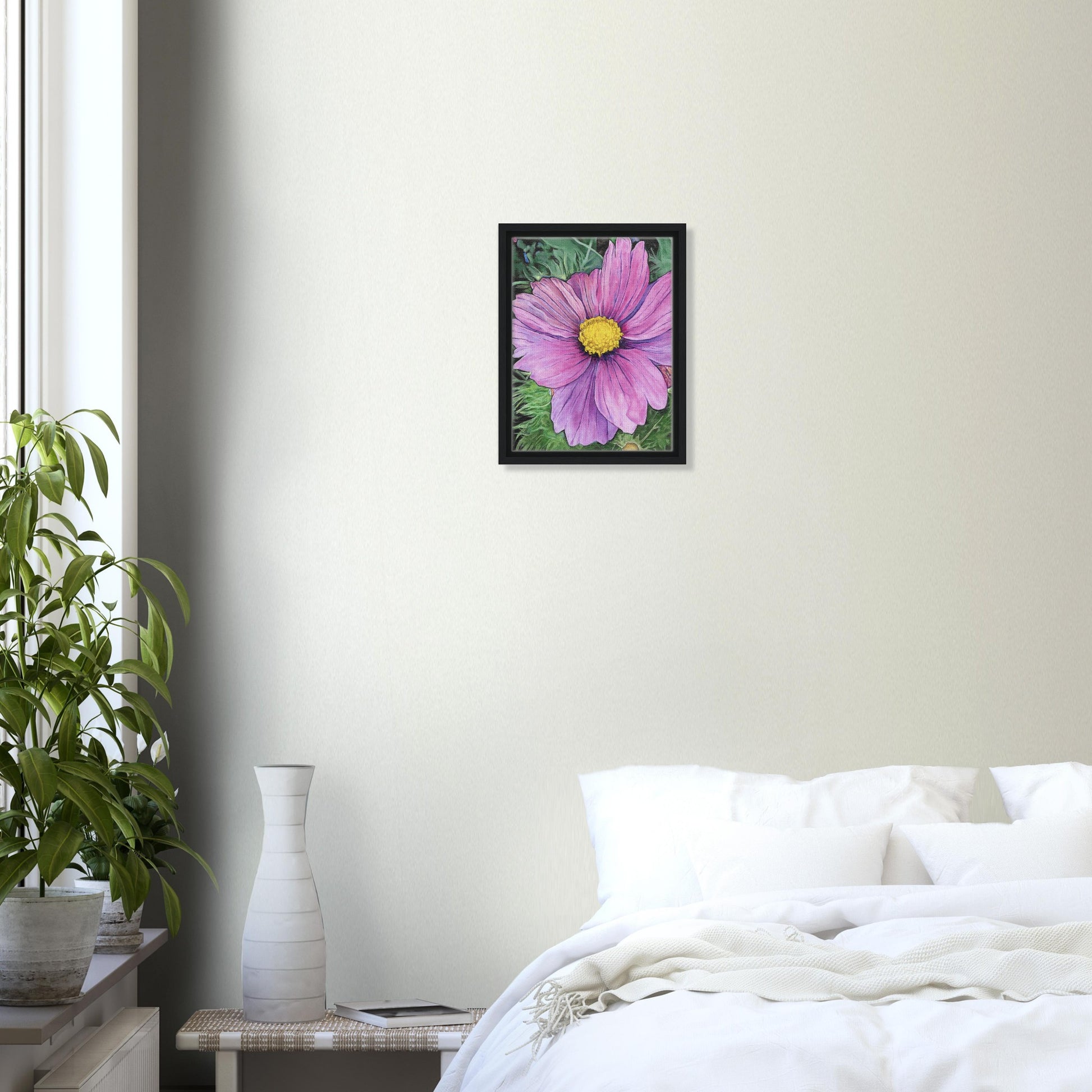 Framed pink flower painting on a wall above a bed in a bedroom.