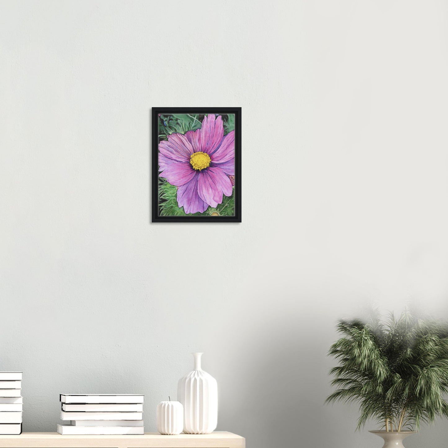 Framed artwork of a purple flower on a white wall with decorative items below.